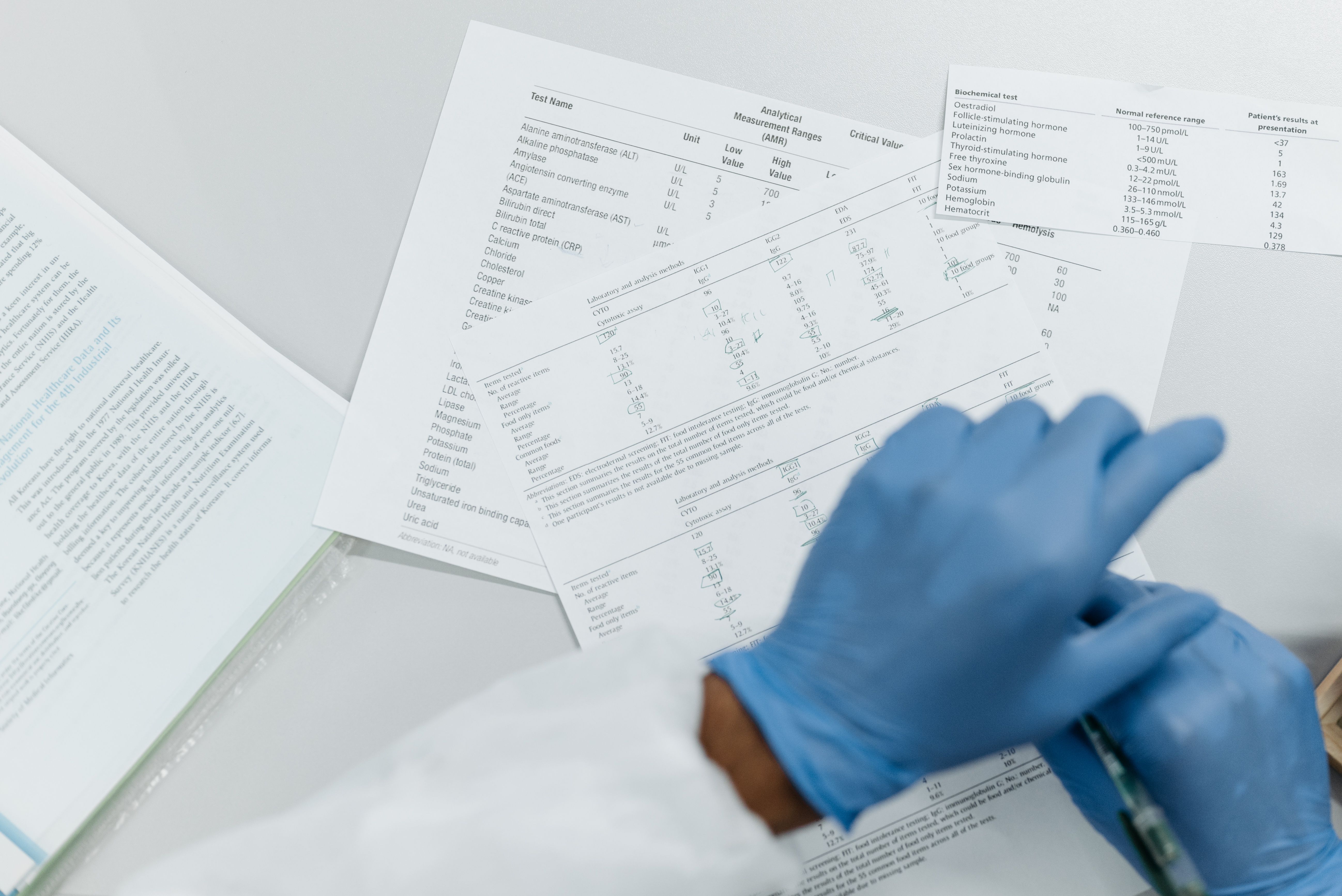 Medical paperwork reviewed with blue gloves